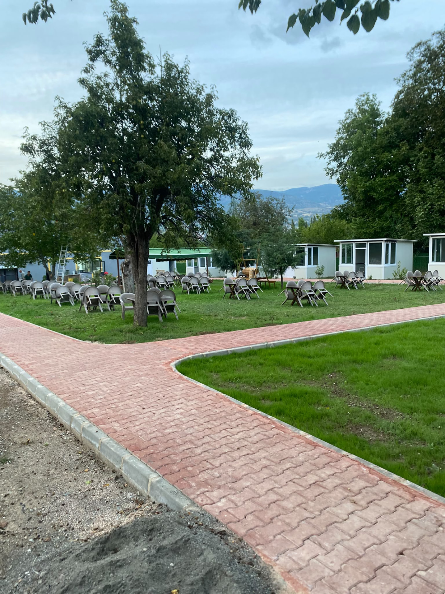 Çim bahçede masa, sandalye ve yürüyüş yolları