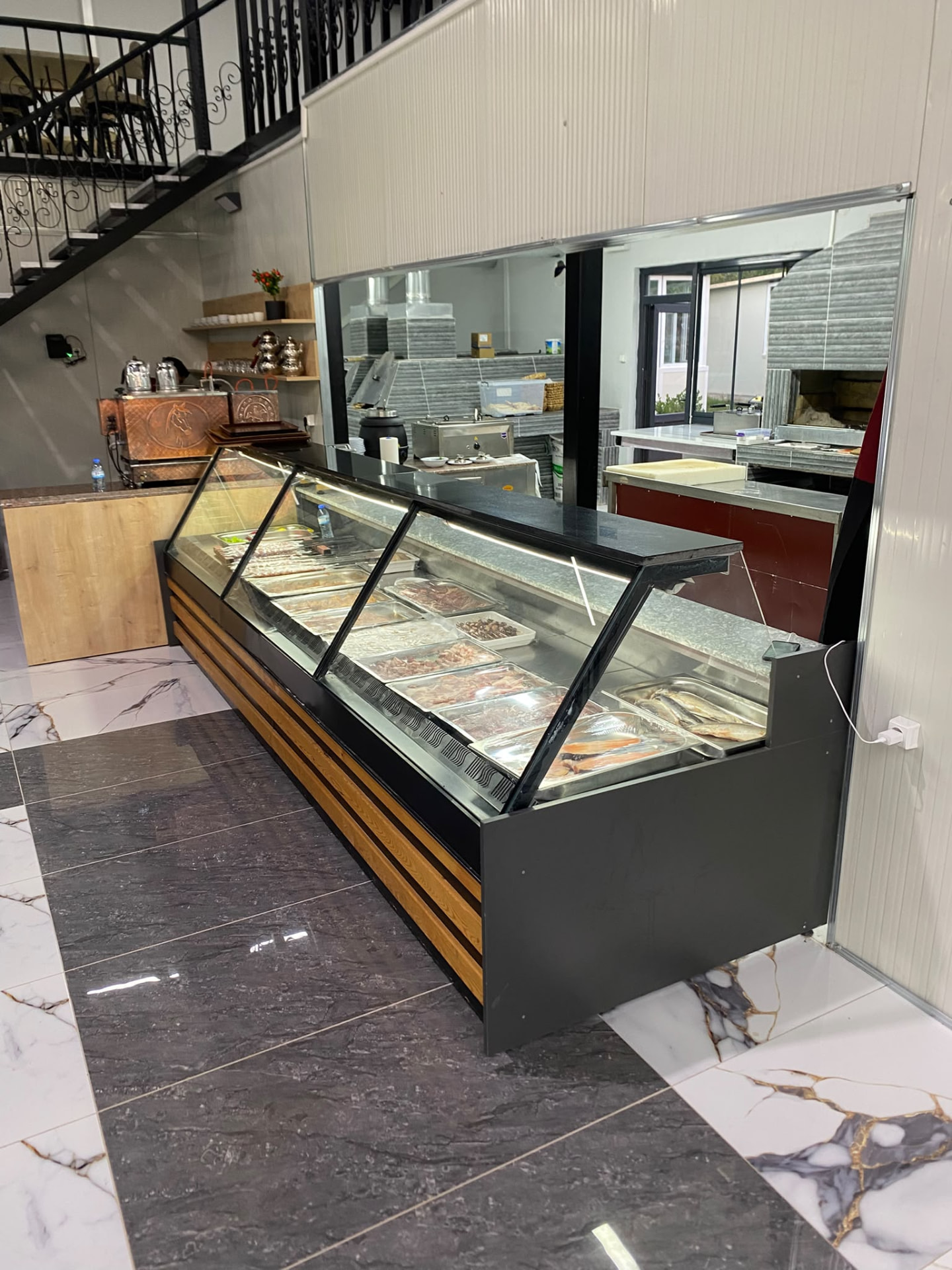 Alvera Cafe Restaurant mutfağındaki teşhir dolabı ve fırın hazırlık alanı